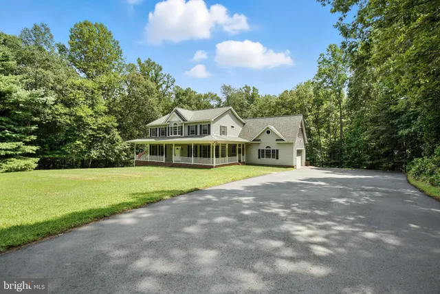 a view of a house with a big yard and large trees