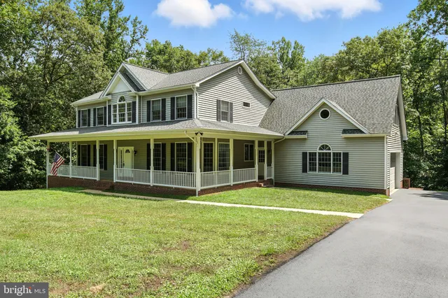 a view of a house with a yard and sitting area