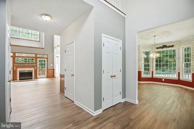 a view of a livingroom with wooden floor a fireplace and windows