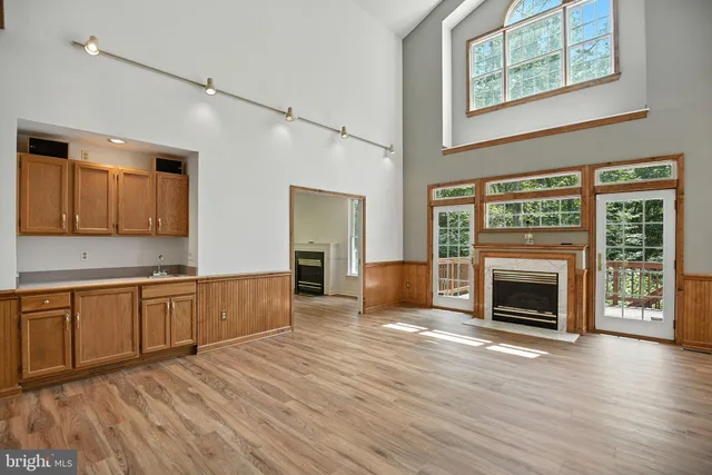 a open kitchen with granite countertop a stove top oven a sink and dishwasher with wooden floor