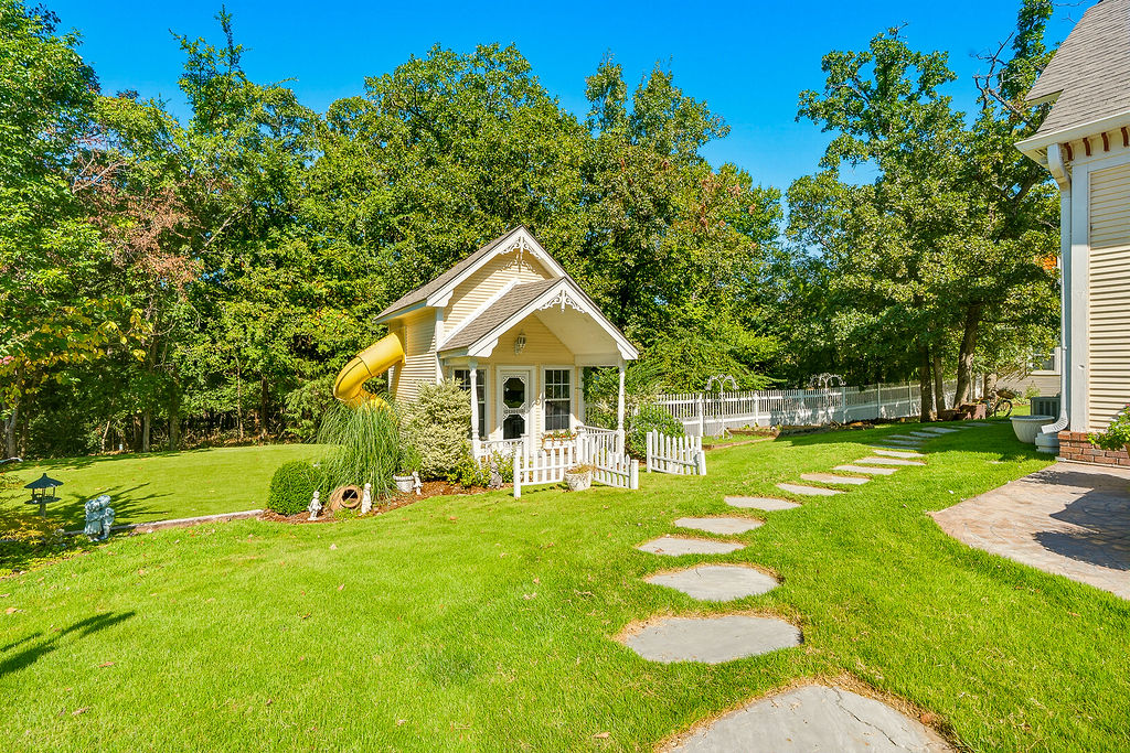 1009 Southeast County Road Ada, OK 74820 - Photo 62 of 92 Expansive lawn featuring a stepping stone pathway, decorative white fence, and mature trees