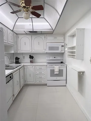 a kitchen with cabinets and white stainless steel appliances