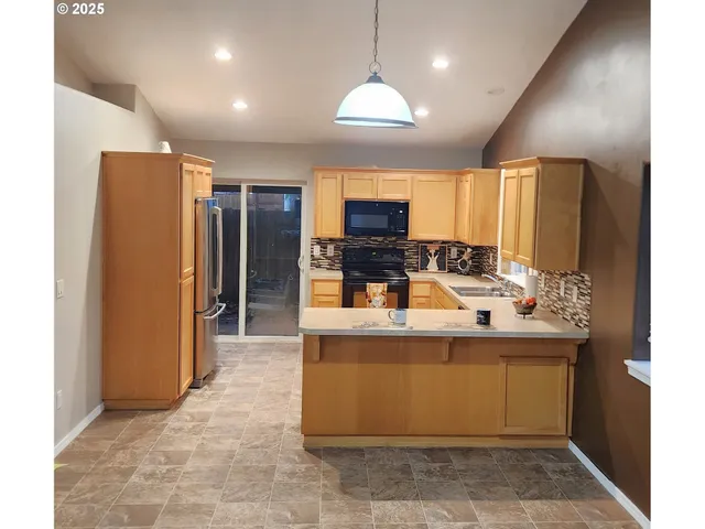 a large kitchen with kitchen island a sink stainless steel appliances and cabinets