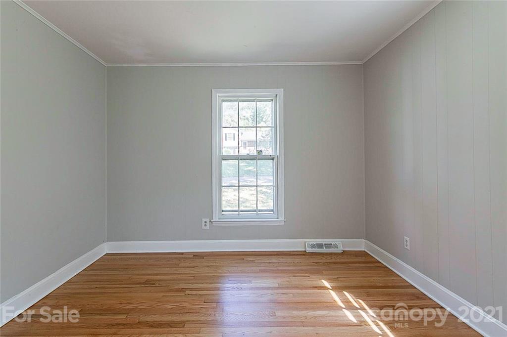 7410 Marlbrook Drive Charlotte, NC 28212 - Photo 12 of 16 a view of empty room with wooden floor and fan