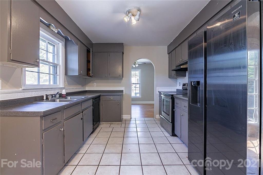 7410 Marlbrook Drive Charlotte, NC 28212 - Photo 7 of 16 a kitchen with a sink a refrigerator and cabinets