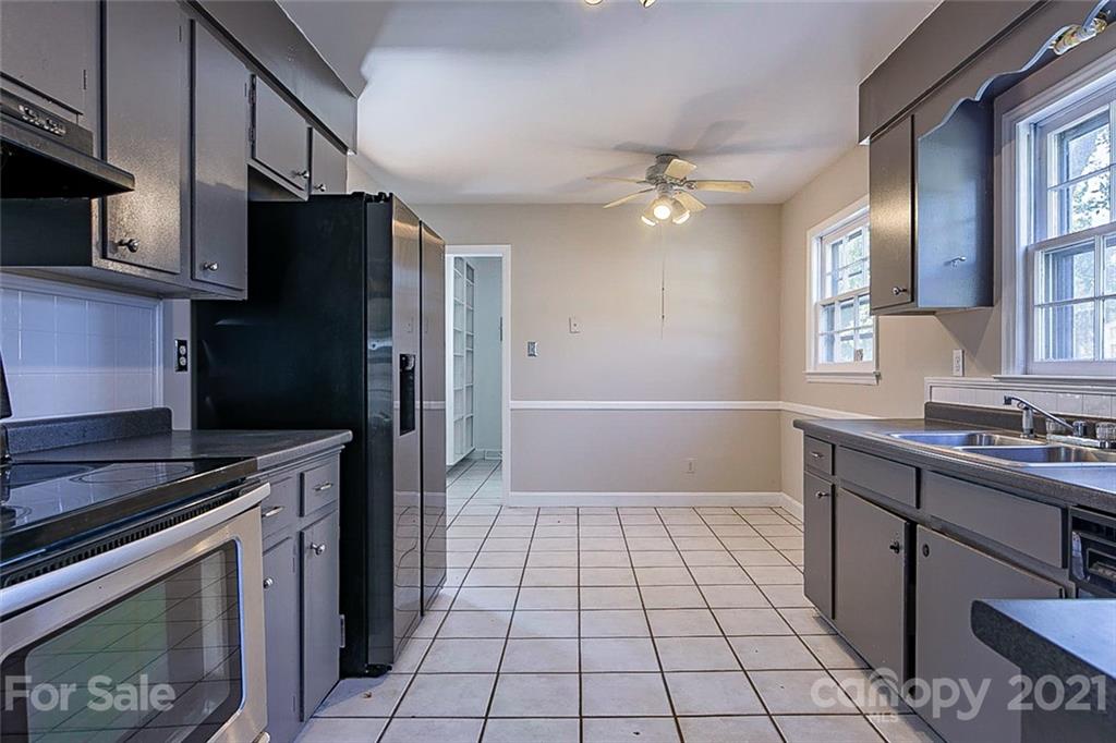 7410 Marlbrook Drive Charlotte, NC 28212 - Photo 8 of 16 a kitchen with stainless steel appliances a stove cabinets and a refrigerator