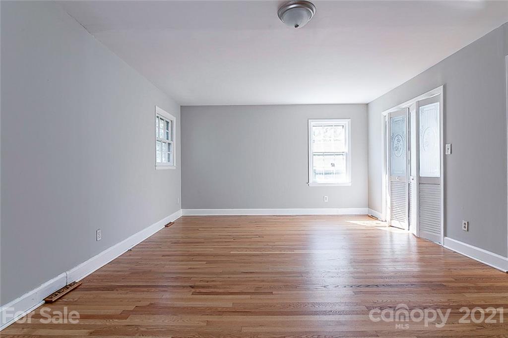 7410 Marlbrook Drive Charlotte, NC 28212 - Photo 10 of 16 an empty room with wooden floor and windows