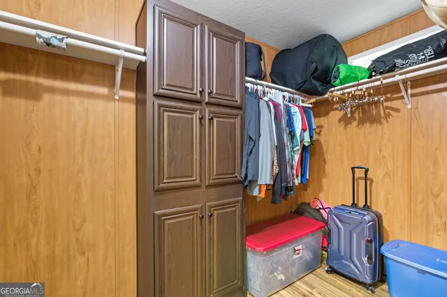 a view of walk in closet with clothes and shoes