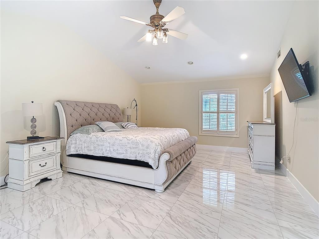 2130 Southwest 37th Street Road Ocala, FL 34471 - Photo 12 of 33 a spacious bedroom with a bed and a flat screen tv