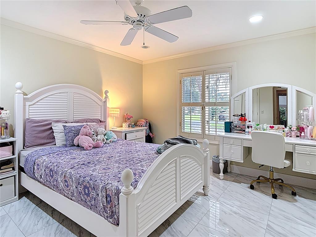 2130 Southwest 37th Street Road Ocala, FL 34471 - Photo 19 of 33 a bedroom with a bed and a chandelier