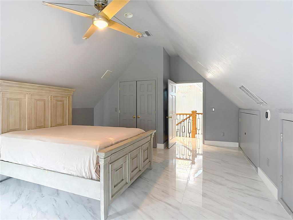 2130 Southwest 37th Street Road Ocala, FL 34471 - Photo 24 of 33 a bedroom with a bed and a chandelier