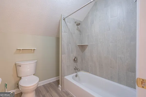 a white toilet sitting next to a bath tub