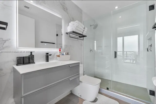a bathroom with a sink a toilet and shower