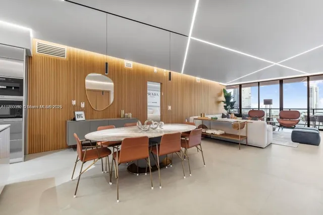 a living room with furniture a table and kitchen view