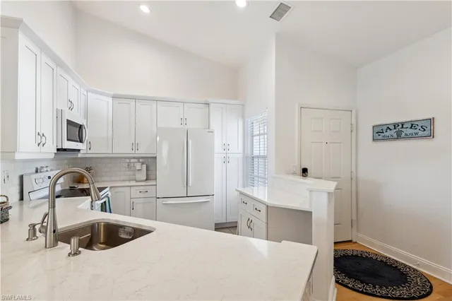 a kitchen with granite countertop a sink a stove and refrigerator