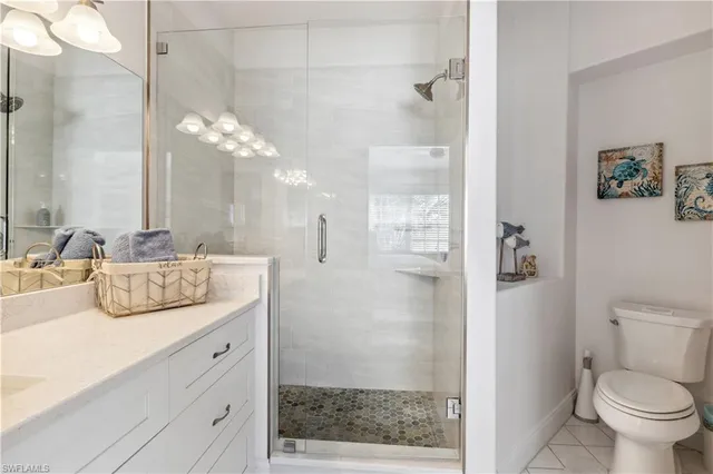 a bathroom with a granite countertop sink a toilet and shower