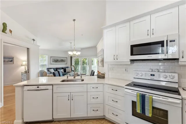 a kitchen with appliances a sink and cabinets