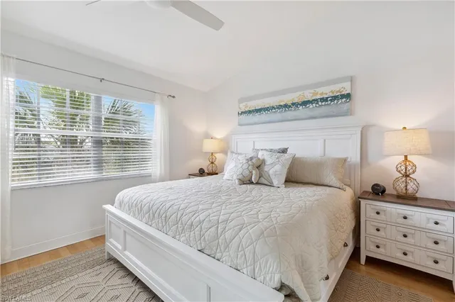 a bedroom with a large bed and a lamp on dresser