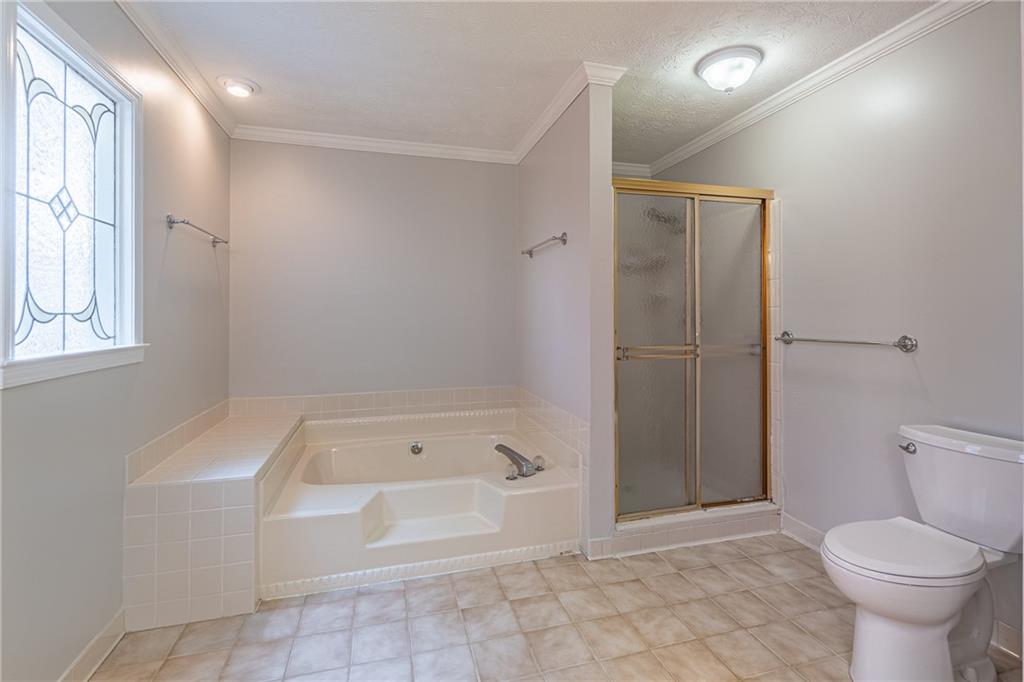 736 Singley Drive Lawrenceville, GA 30044 - Photo 16 of 33 a bathroom with a bathtub and a toilet