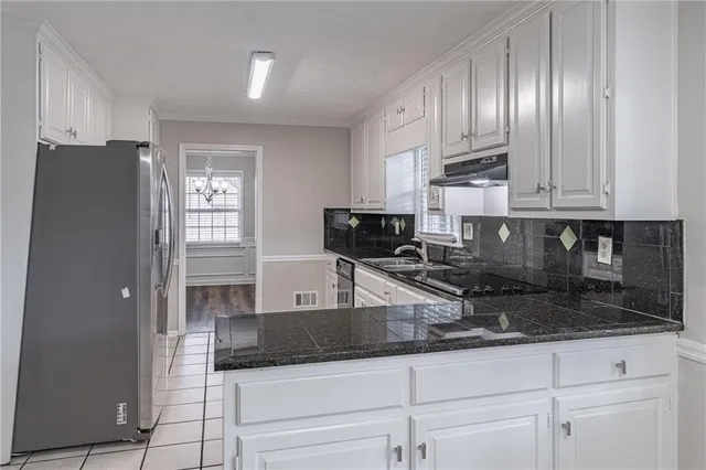 a kitchen with granite countertop a refrigerator a stove and cabinets