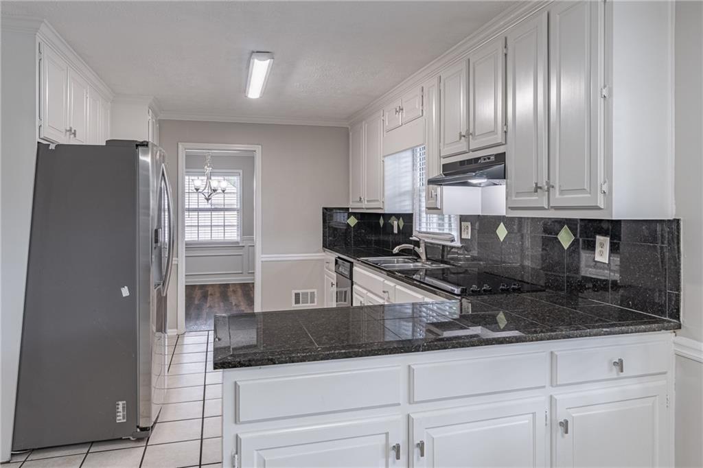 736 Singley Drive Lawrenceville, GA 30044 - Photo 7 of 33 a kitchen with granite countertop a refrigerator a stove and cabinets