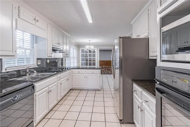a large kitchen with a stove a sink and a refrigerator