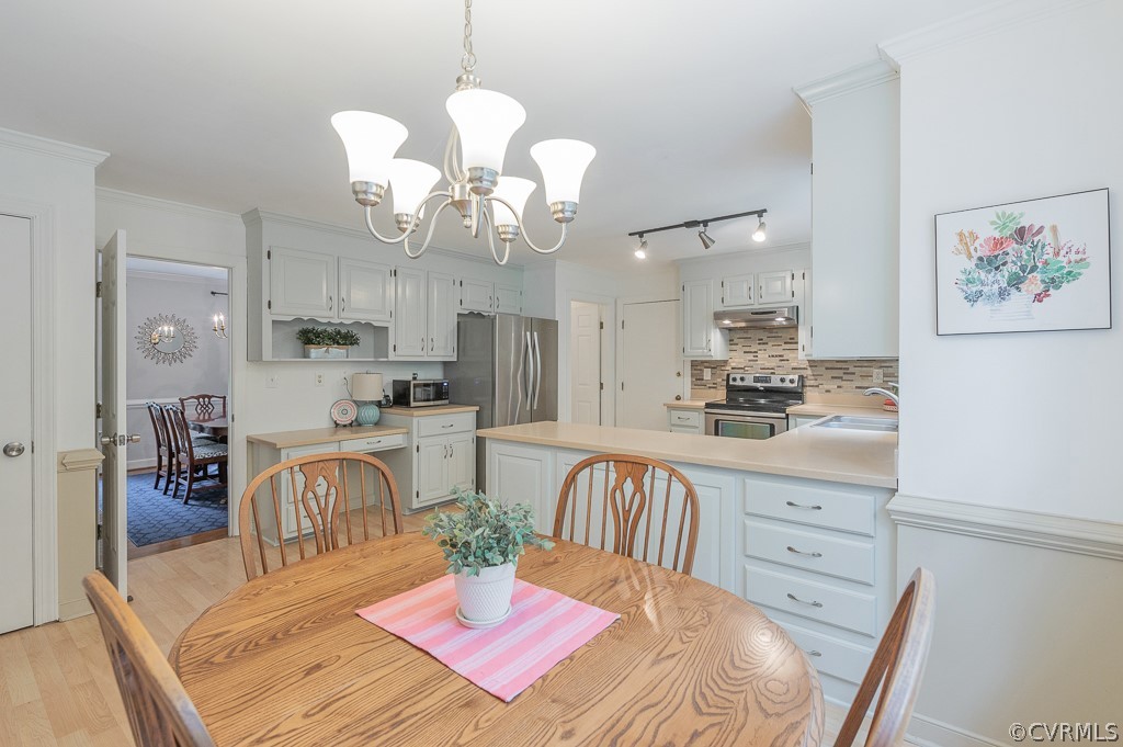 14202 Long Gate Road Midlothian, VA 23112 - Photo 6 of 27 a dining room with wooden floor a chandelier a wooden table and chairs