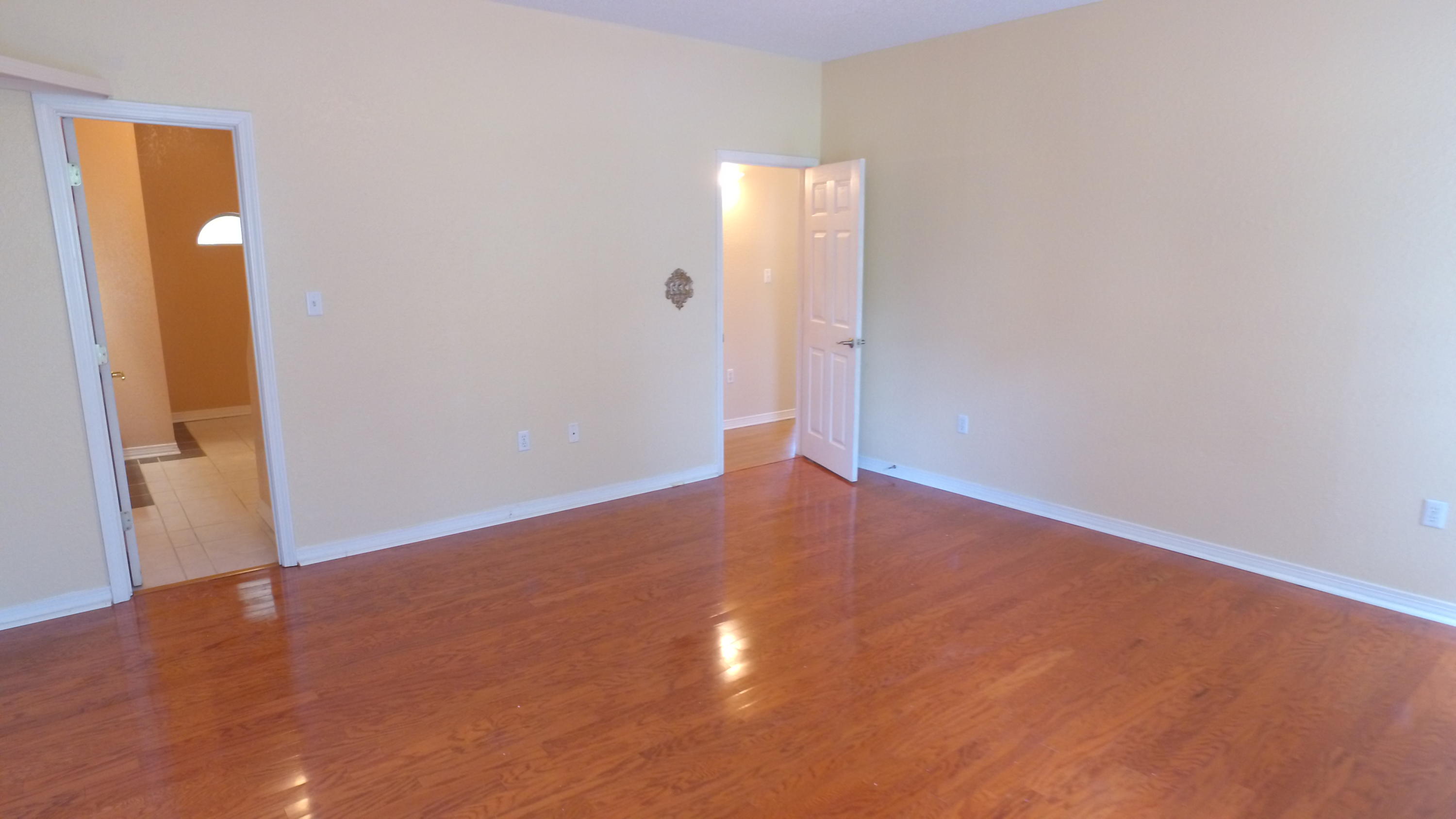 564 Ridge Lake Road Crestview, FL 32536 - Photo 31 of 58 an empty room with wooden floor and mirror