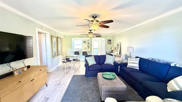 a living room with furniture a flat screen tv and a window