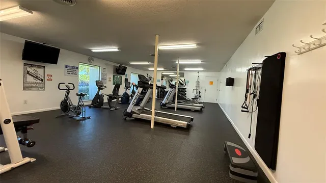 a living room with a table chairs and a refrigerator