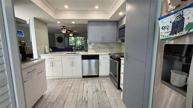 a kitchen with kitchen island granite countertop a refrigerator oven a sink a dining table and chairs