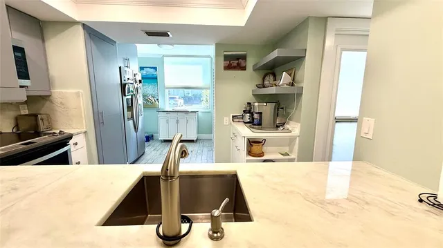 a kitchen with stainless steel appliances a sink a microwave and cabinets