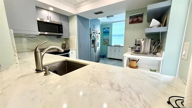 a kitchen with stainless steel appliances granite countertop a refrigerator and a sink