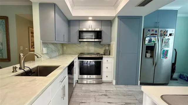 a kitchen with stainless steel appliances a stove a sink and a refrigerator