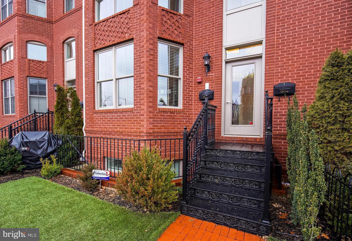 1904 Vermont Avenue Northwest, Unit B Washington, DC 20001 - Photo 1 of 26 a view of a house with a small yard and large tree and wooden fence