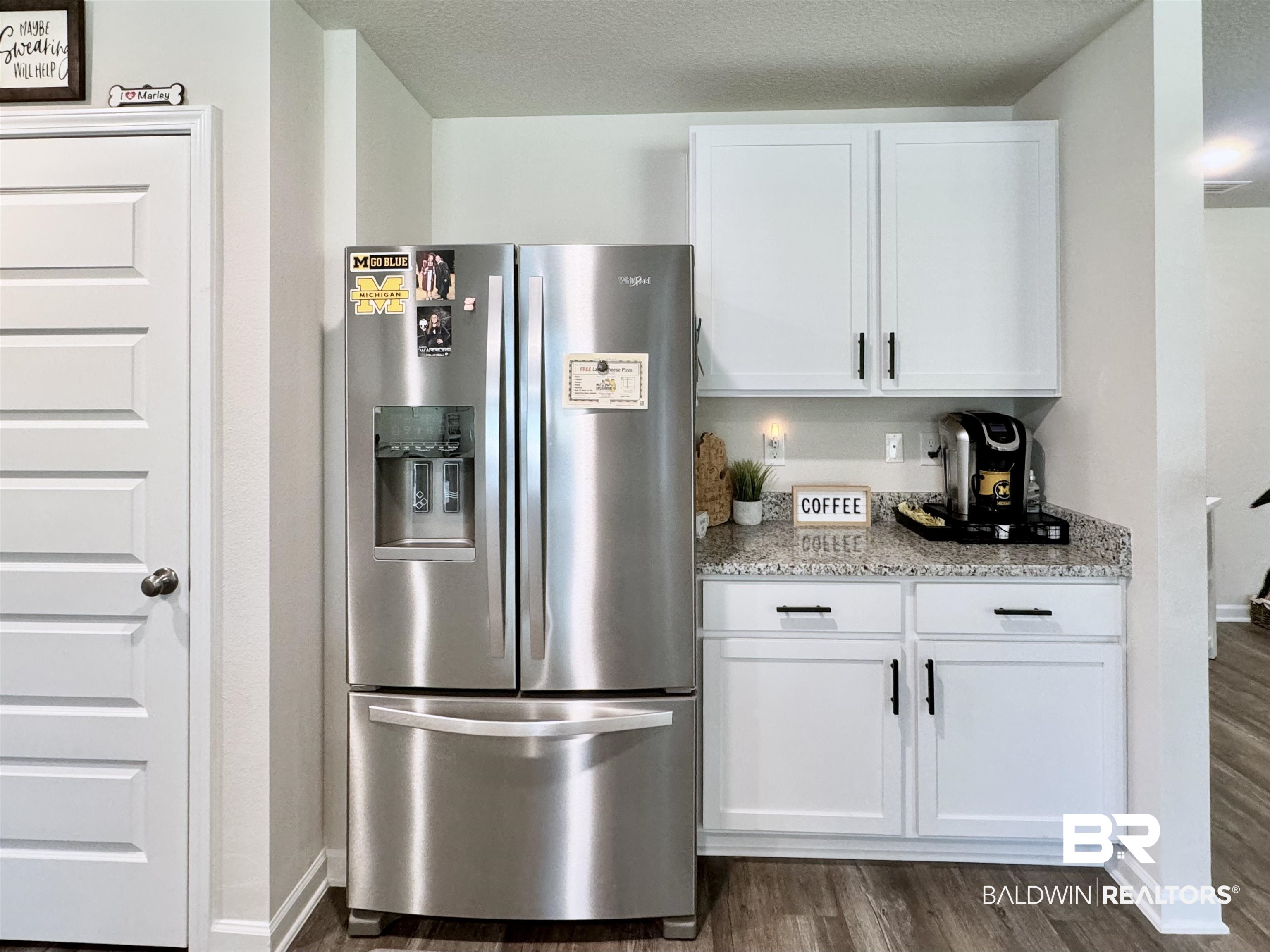 24216 Ringneck Loop Elberta, AL 36530 - Photo 23 of 23 Kitchen featuring stainless steel fridge with ice dispenser, white cabinets, dark wood-style floors, light stone counters, and a textured ceiling