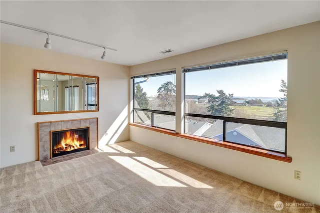 a living room with fireplace and a large window