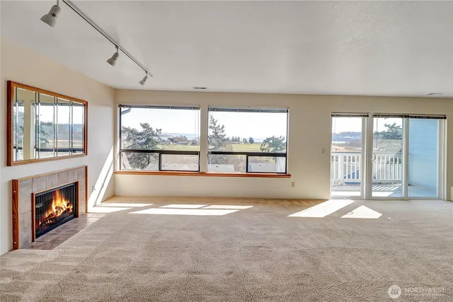 a view of an empty room with a fireplace and a large window