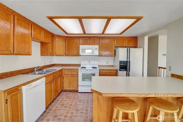 a kitchen with stainless steel appliances granite countertop a sink a stove and a refrigerator