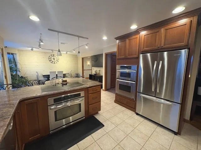 a modern kitchen with stainless steel appliances and refrigerator