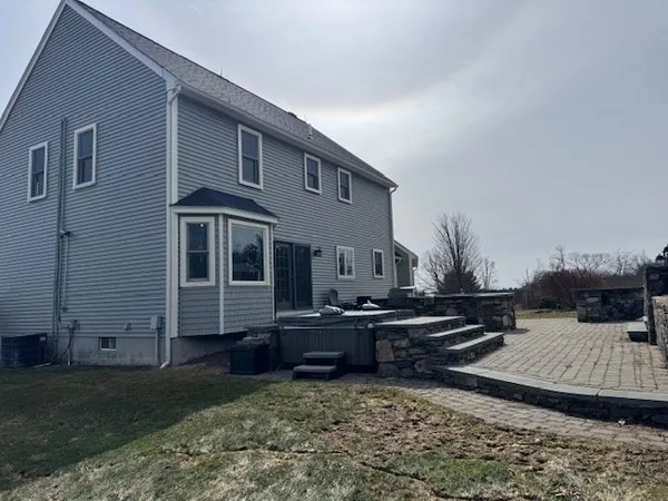 a bedroom with a bed a mirror on the dresser and a window