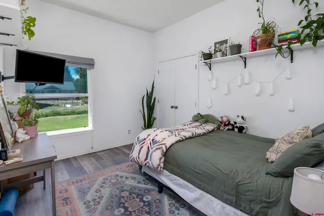 a bedroom with a bed flat screen tv and window