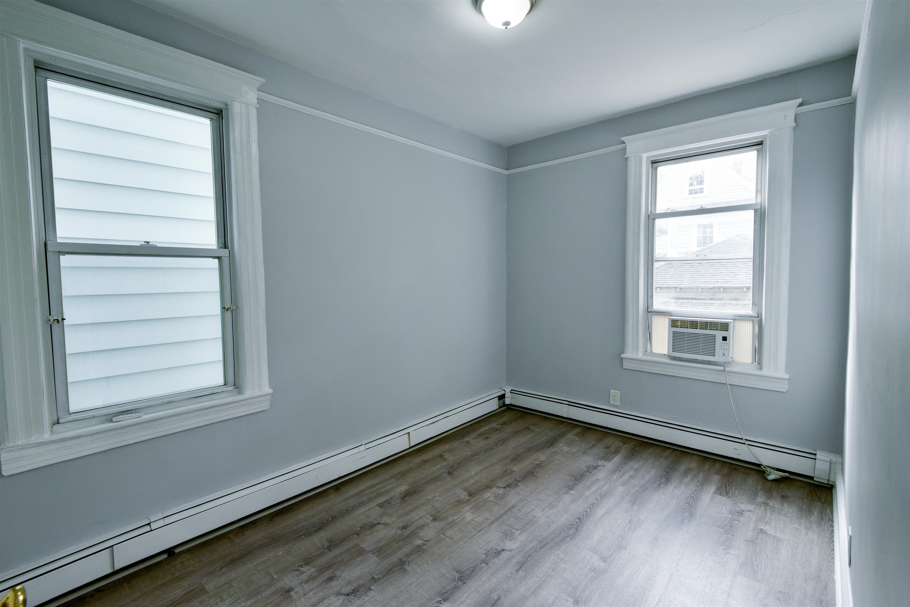 108 West 42nd Street, Unit 1 Bayonne, NJ 07002 - Photo 12 of 21 a view of a room with wooden floor and windows