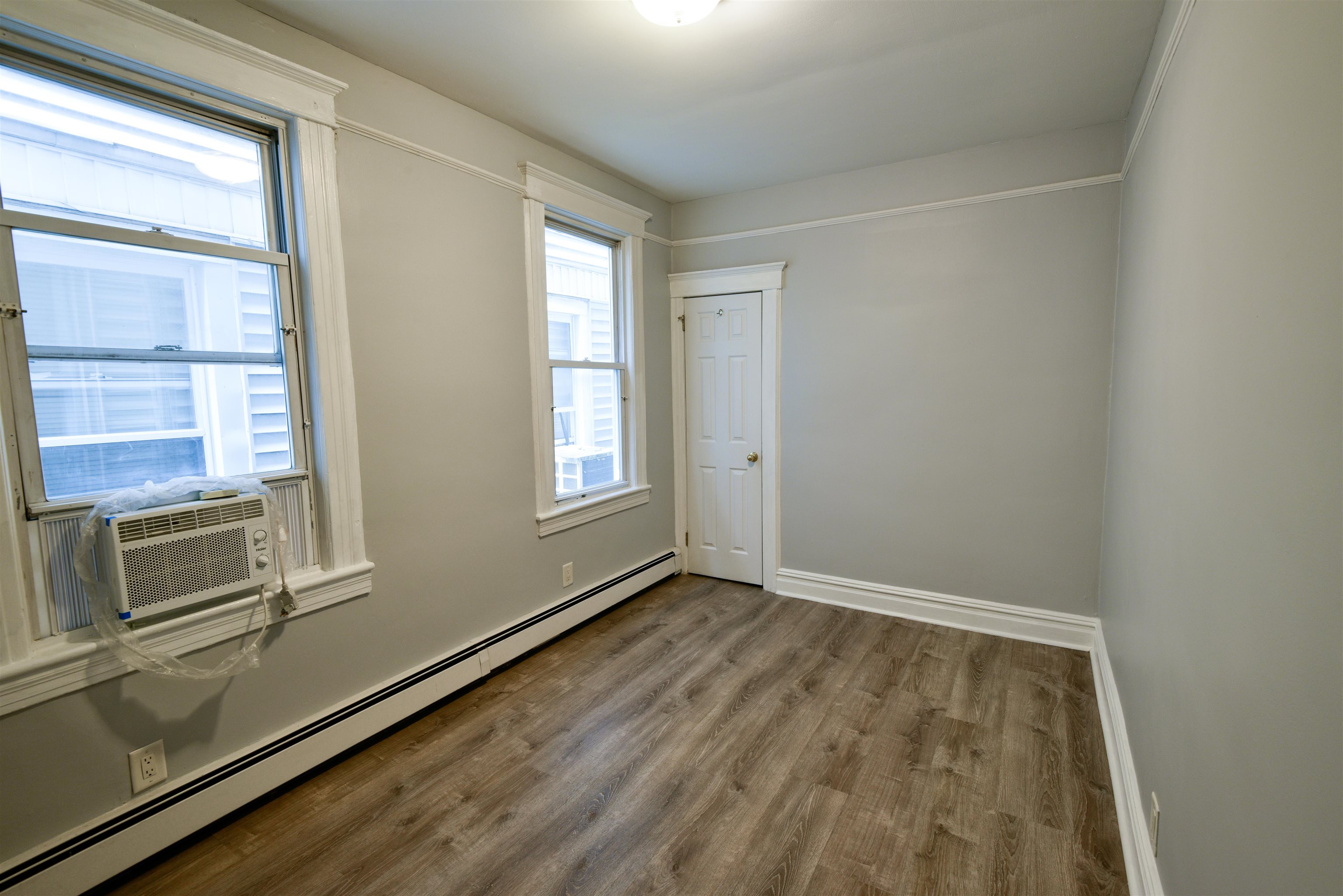 108 West 42nd Street, Unit 1 Bayonne, NJ 07002 - Photo 13 of 21 an empty room with wooden floor and windows