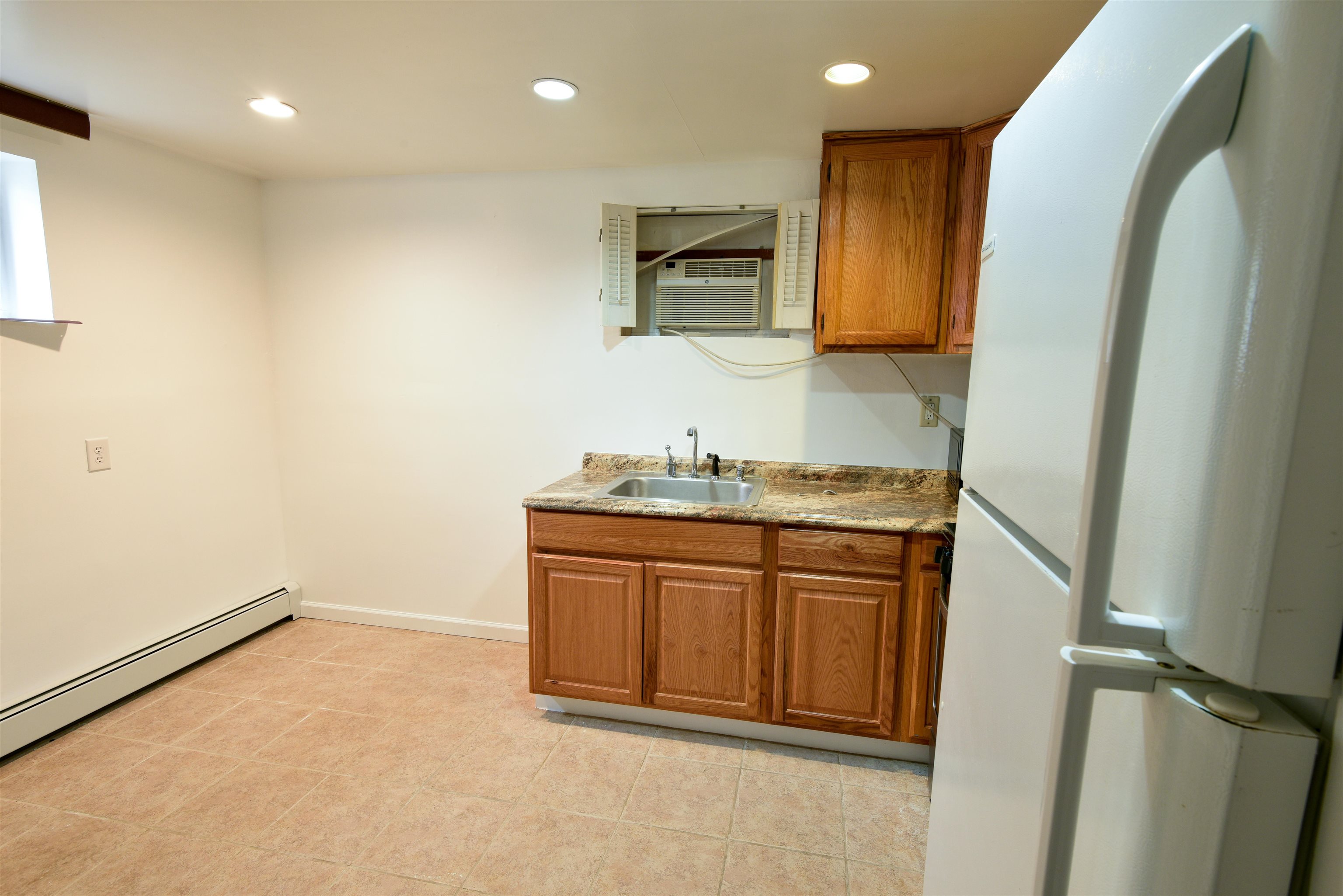108 West 42nd Street, Unit 1 Bayonne, NJ 07002 - Photo 3 of 21 a bathroom with a granite countertop sink and a mirror
