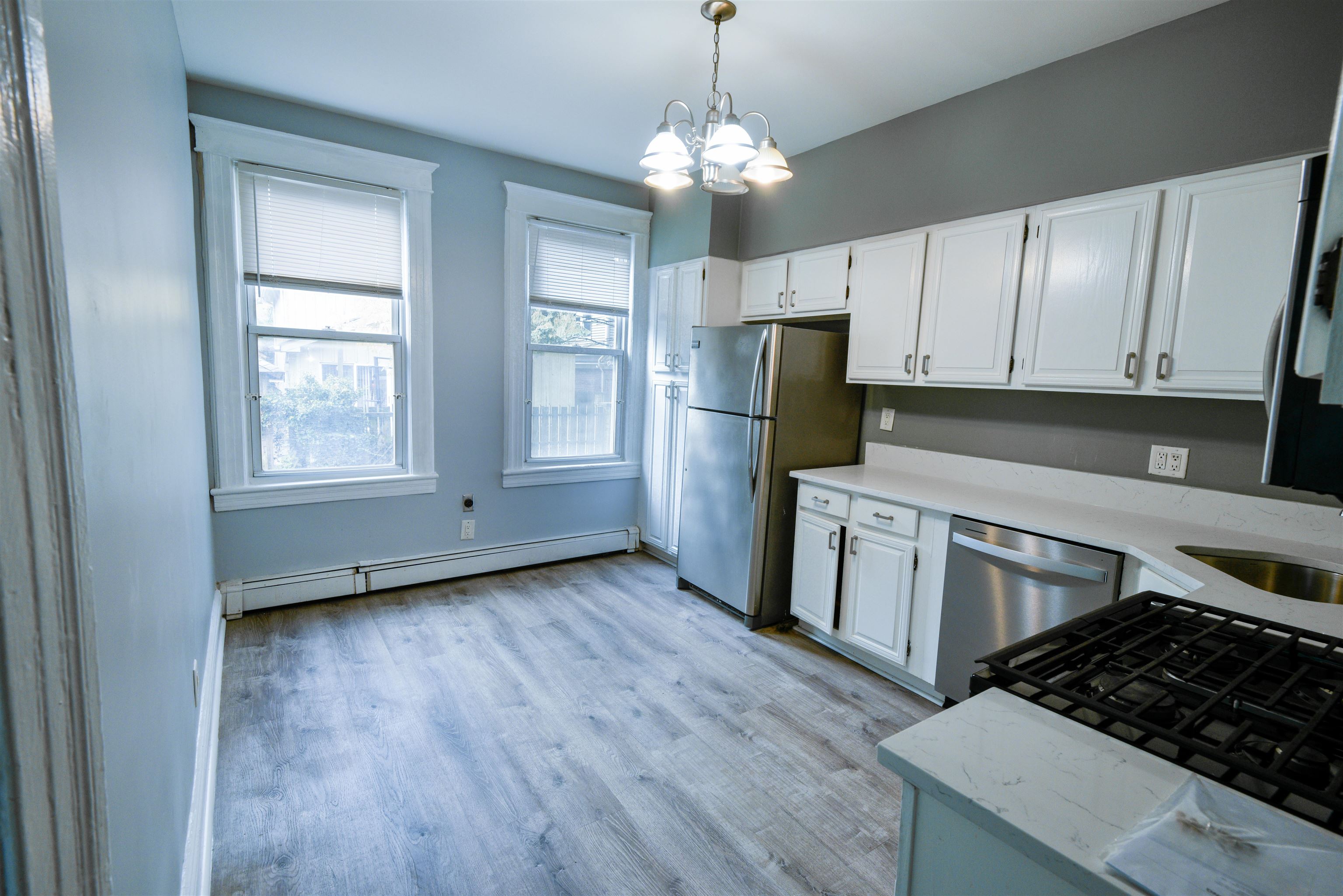 108 West 42nd Street, Unit 1 Bayonne, NJ 07002 - Photo 4 of 21 a kitchen with stainless steel appliances a stove a refrigerator and cabinets