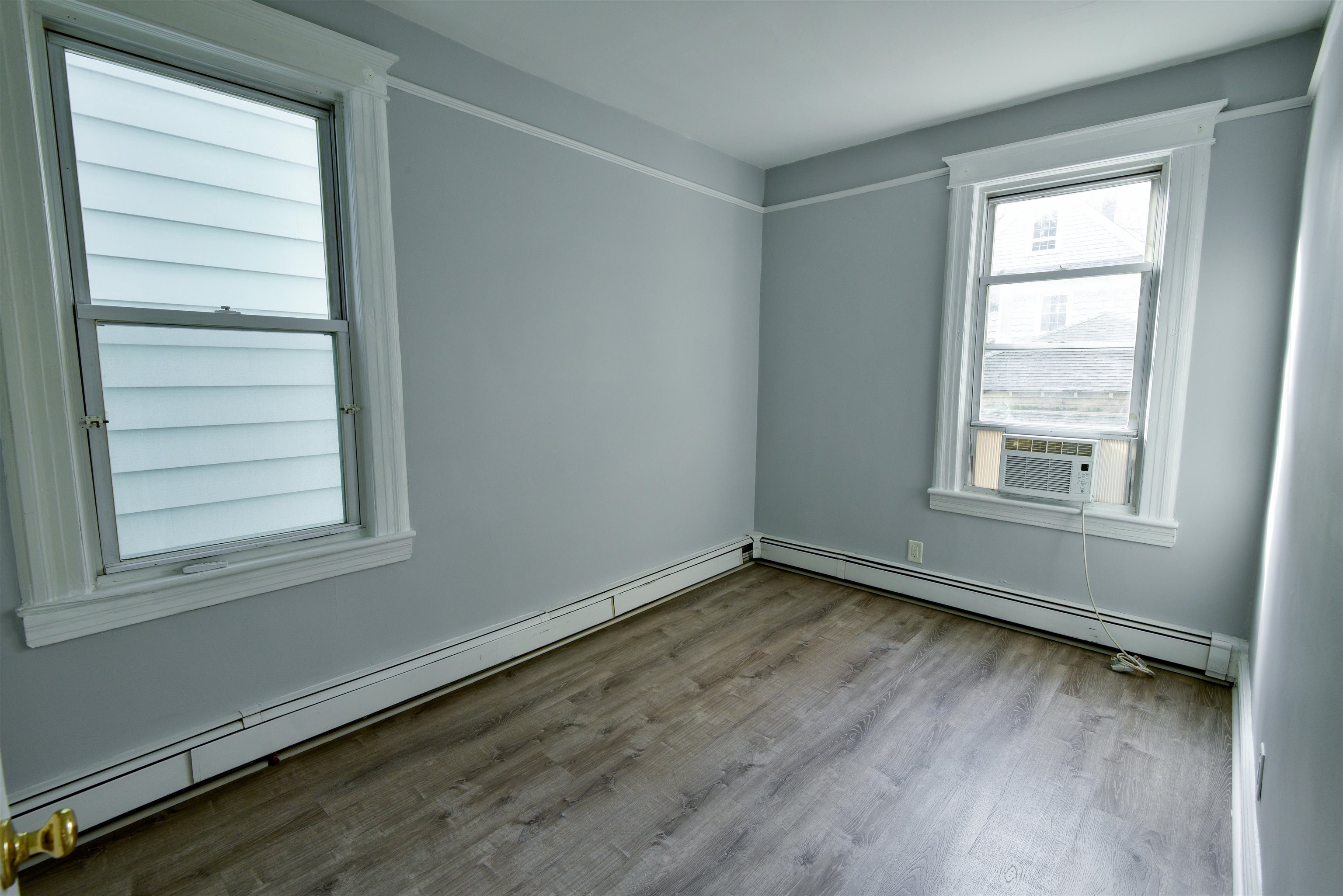 108 West 42nd Street, Unit 1 Bayonne, NJ 07002 - Photo 9 of 21 a view of an empty room with wooden floor and a window