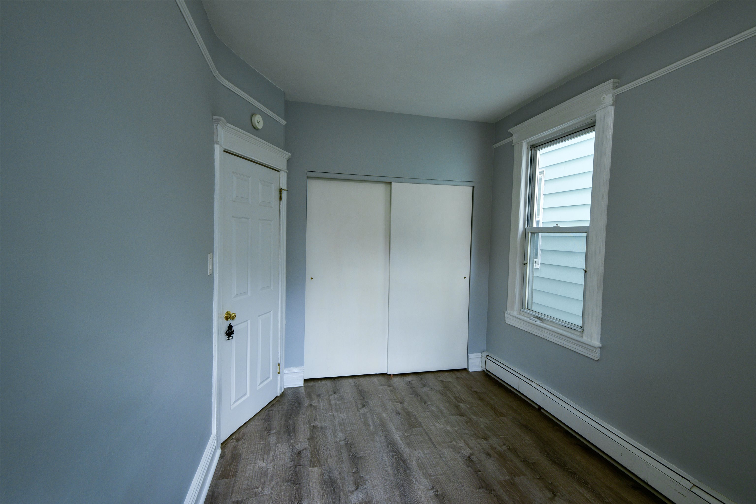 108 West 42nd Street, Unit 1 Bayonne, NJ 07002 - Photo 10 of 21 a view of an empty room with wooden floor and a window
