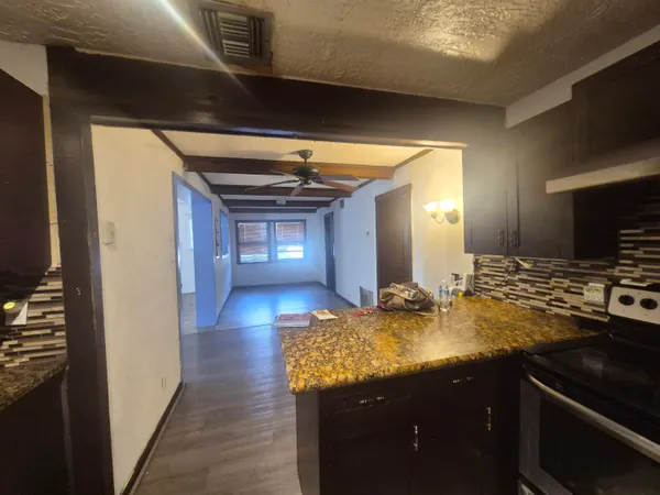 a kitchen with kitchen island granite countertop a sink and stove