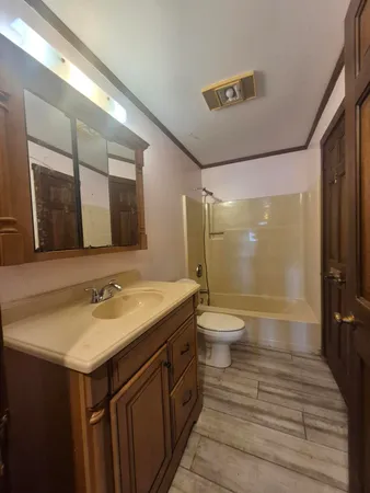a bathroom with a granite countertop sink toilet a large mirror and shower